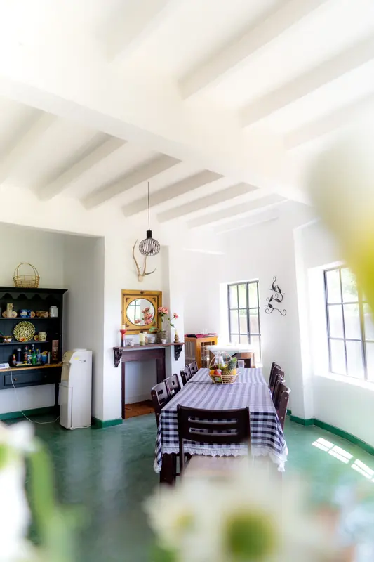 The dining room: a checked tablecloth under a white beamed ceiling