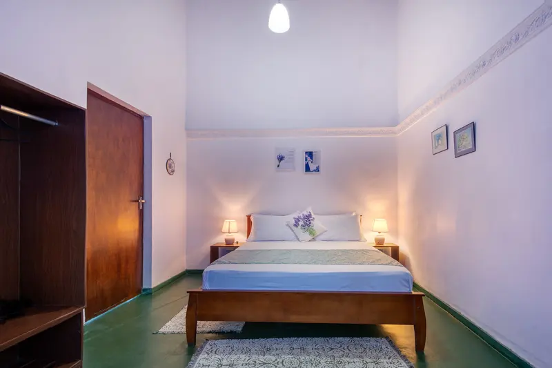 Lavender bedroom: a double bed with a lavender runner and a lamp each side