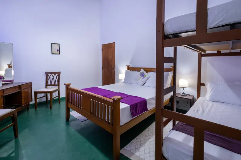 Violet bedroom: a double bed with a purple runner and a bunk bed